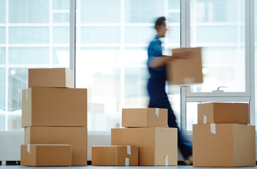 Blurred,Motion,Of,Contemporary,Worker,With,Packed,Box,Walking,To